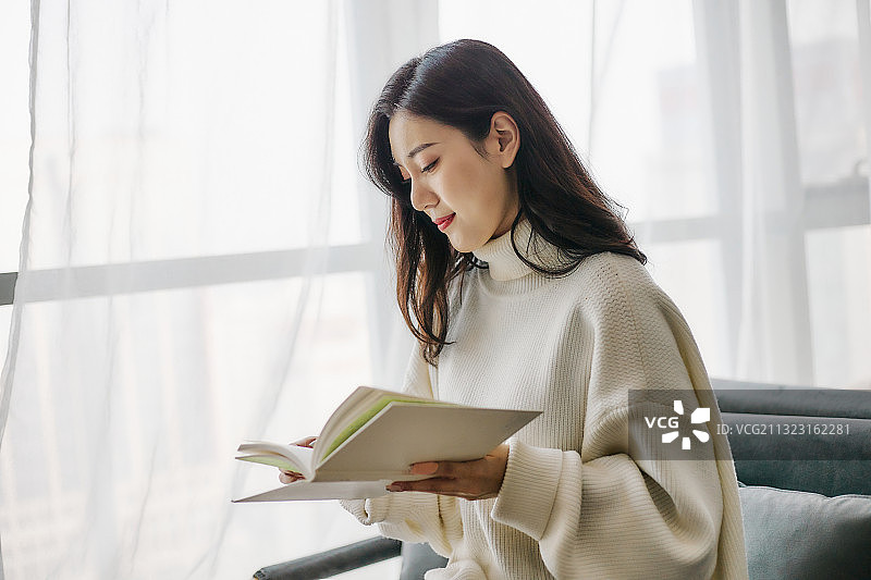 在咖啡厅看书的年轻中国女孩图片素材