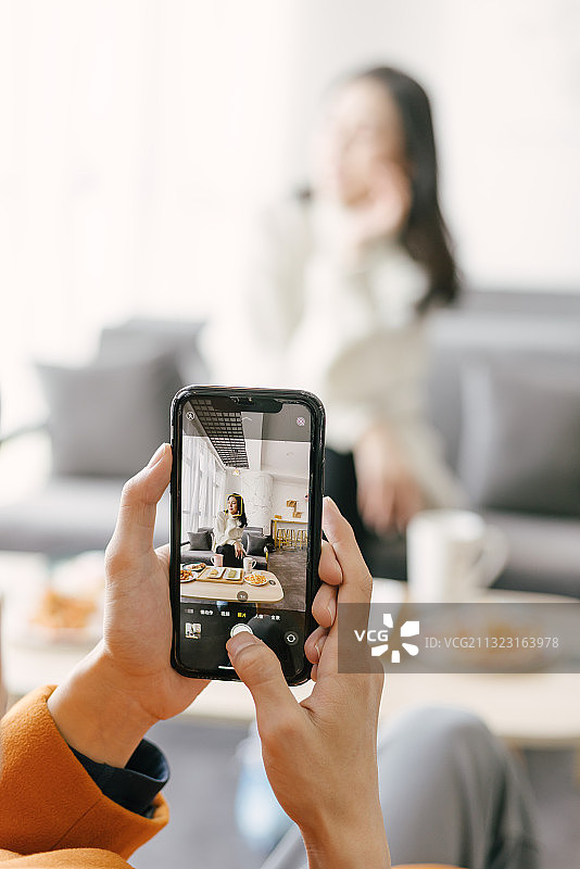 用手机为年轻模特拍照图片素材