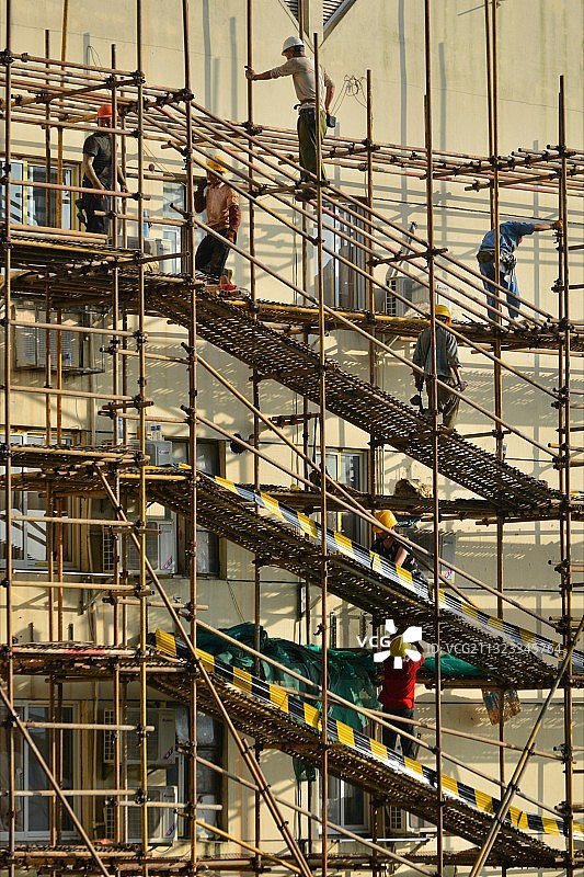 夏日，建筑工人搭施工脚手架的场景图片素材