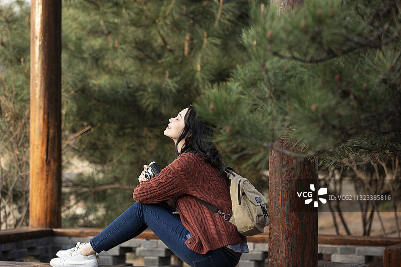 春天青年女子城市旅行拍照休息图片素材