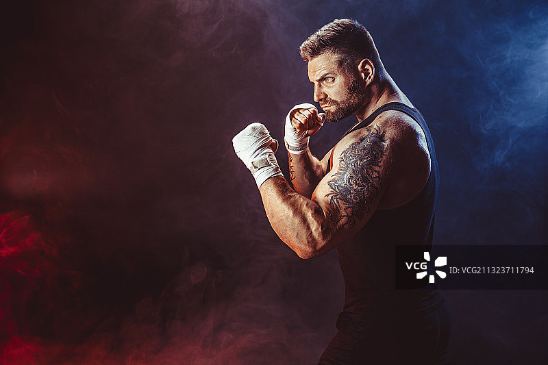 站在黑色背景前的拳击手肖像图片素材