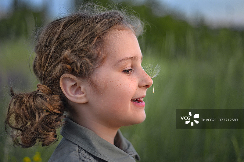 微笑的女孩看向远方的侧视图图片素材