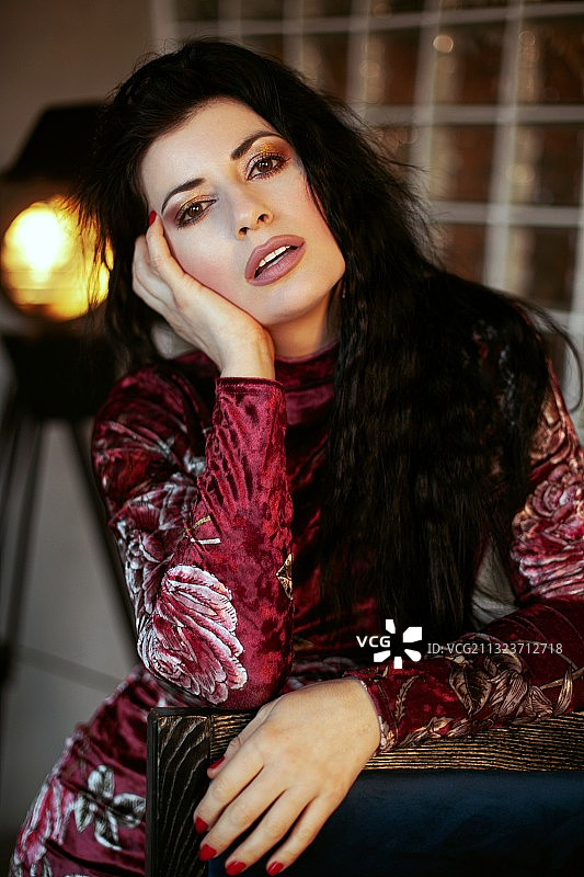 美丽年轻女子坐在椅子上的肖像图片素材