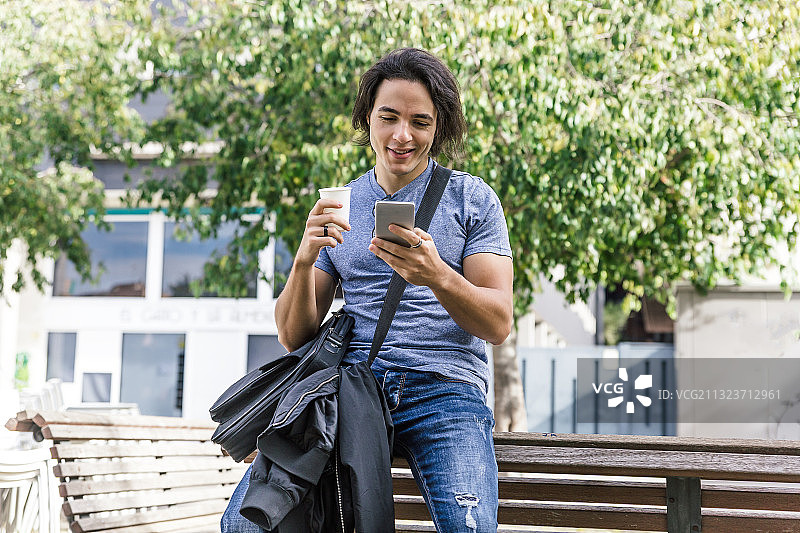男人在街上用智能手机喝咖啡图片素材