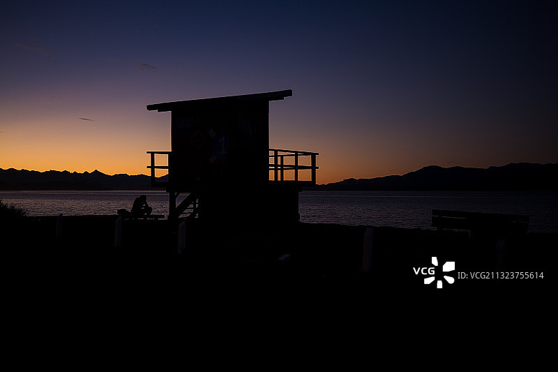 阿根廷圣卡洛斯-德巴里洛切海滩上救生员小屋的日落轮廓图片素材