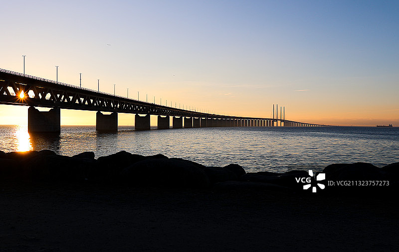 日落时分海上桥梁的剪影图片素材