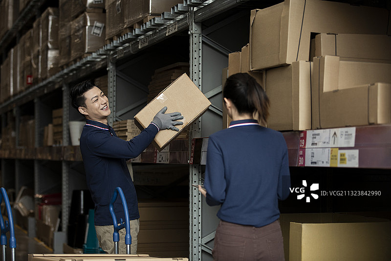 两个青年男女在物流仓库工作图片素材