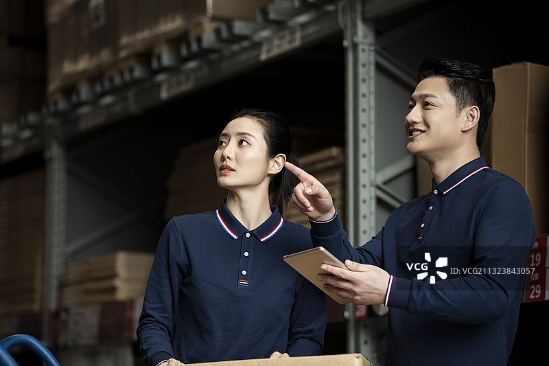 两个青年男女在物流仓库工作图片素材