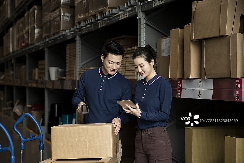 两个青年男女在物流仓库工作图片素材