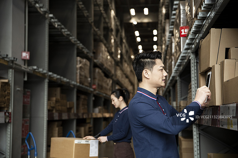 两个青年男女在物流仓库工作肖像图片素材