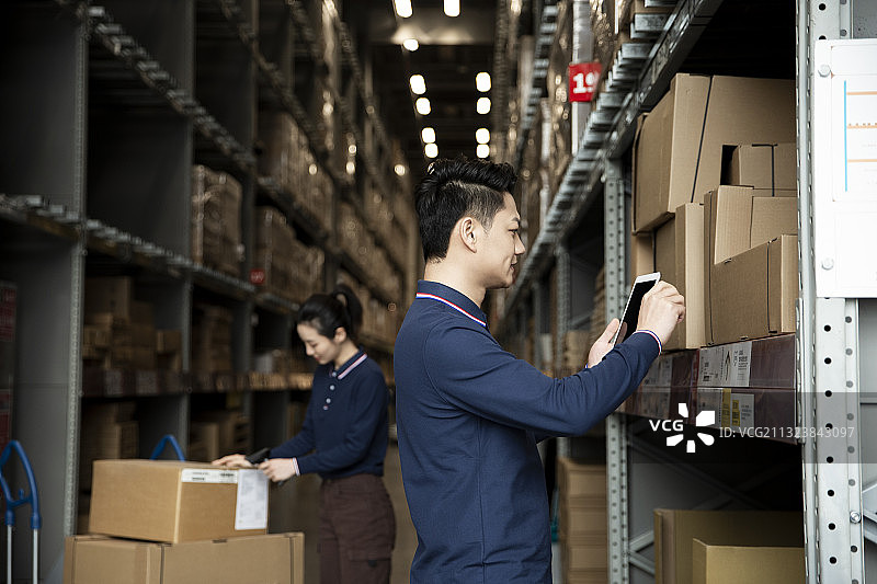 两个青年男女在物流仓库工作图片素材