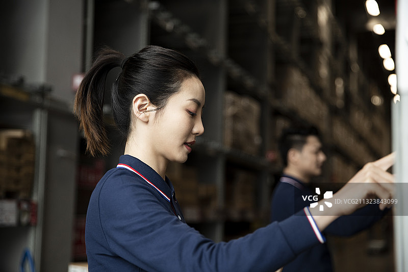 两个青年男女在物流仓库工作图片素材