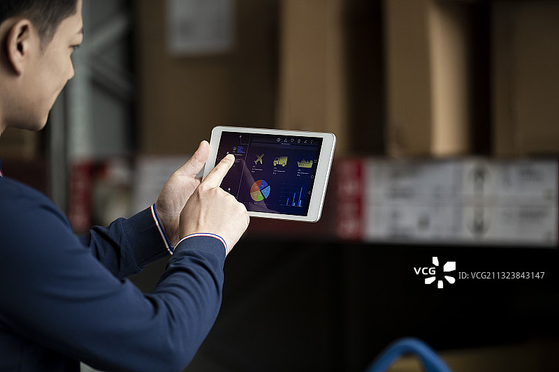 青年男子在物流仓库使用平板电脑工作肖像图片素材