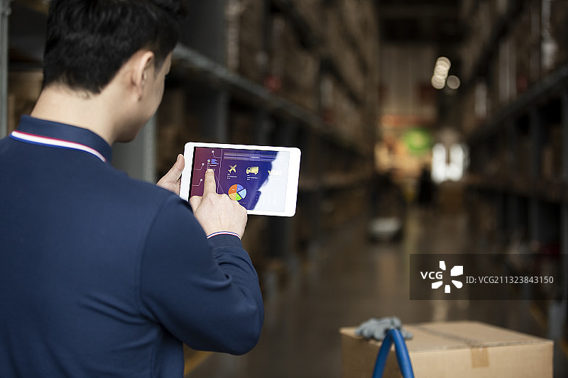 青年男子在物流仓库使用平板电脑工作肖像图片素材