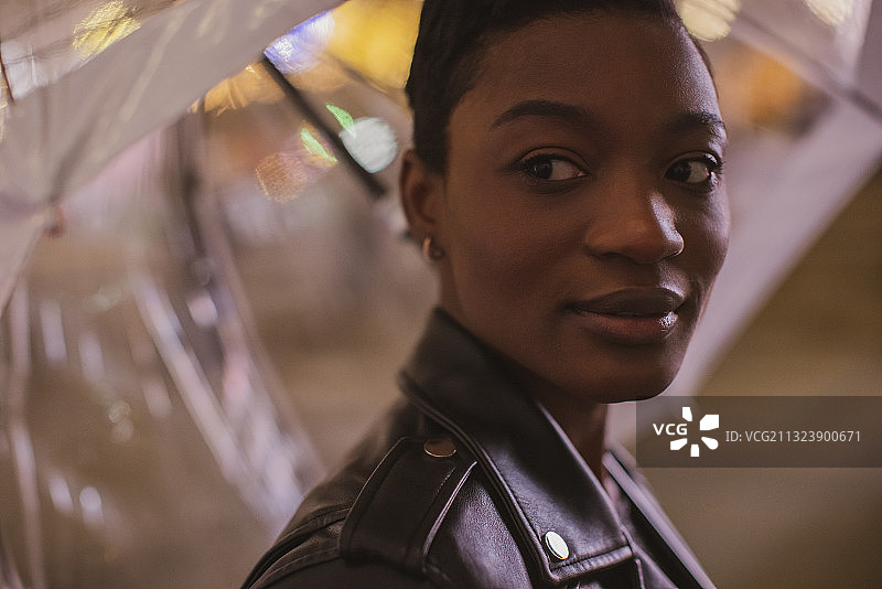 在雨伞下美丽的年轻女人特写图片素材