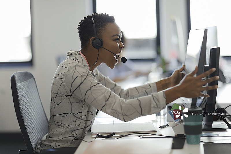 沮丧的女商人摇晃办公桌上的电脑显示器图片素材