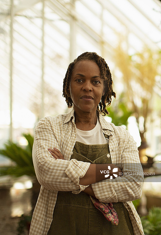 自信的女园艺店主肖像，双手交叉图片素材
