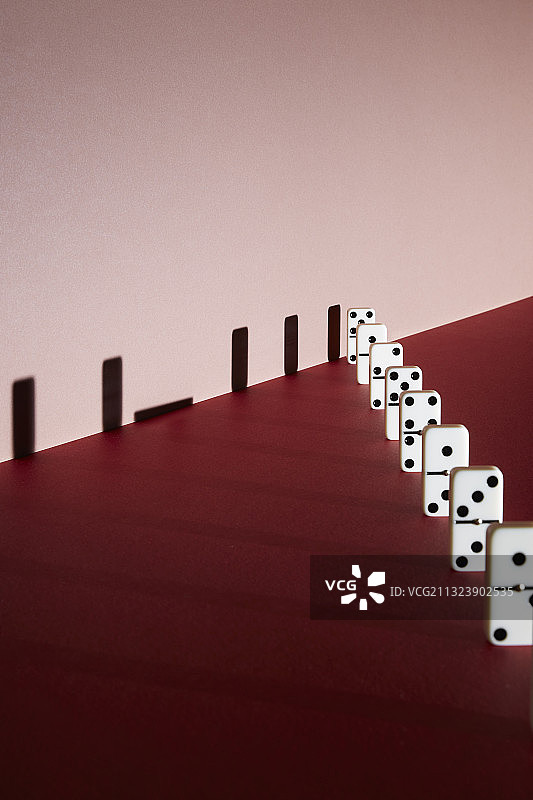 红色背景上倒下的多米诺阴影图片素材