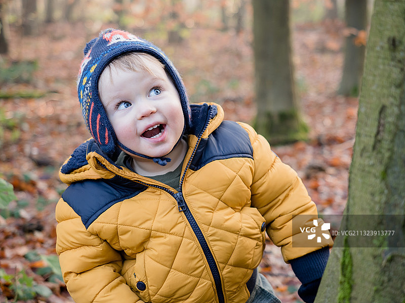 秋季森林里看向远方的可爱小男孩图片素材
