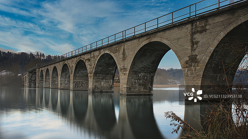 仰视河上的拱桥，以天空为背景图片素材