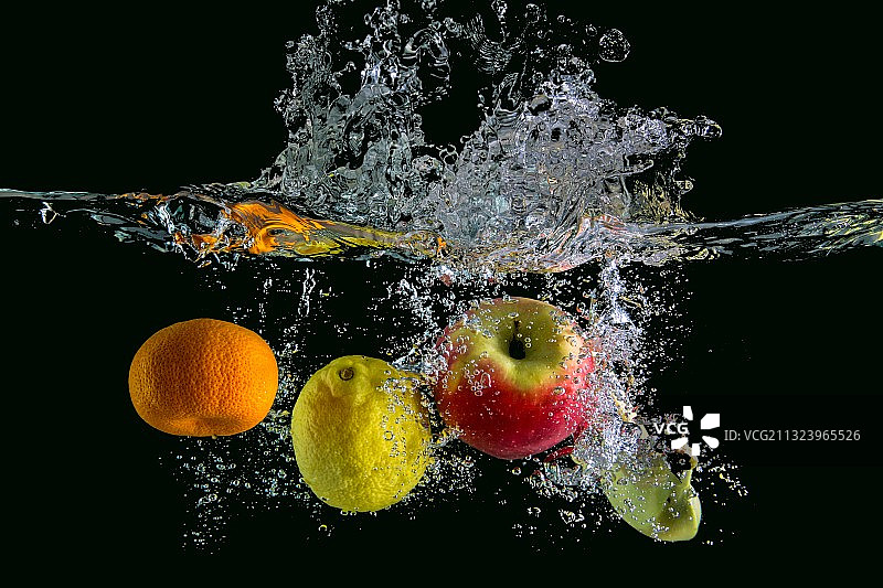 黑色背景下，水中的水果特写图片素材