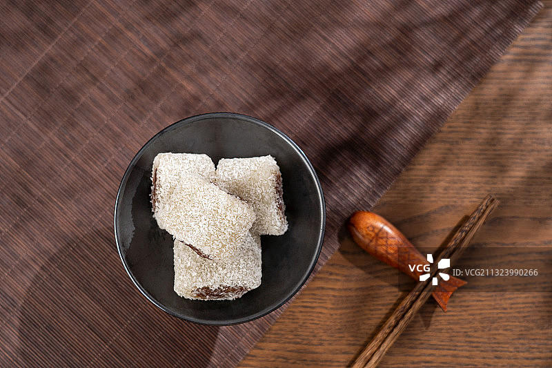 北京传统小吃风味特产木制桌子上的驴打滚和黄豆面图片素材