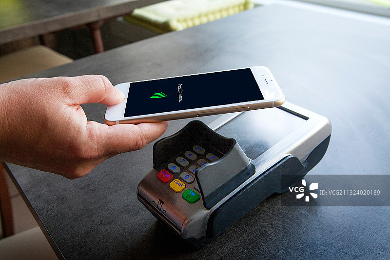 女人用智能手机支付图片素材