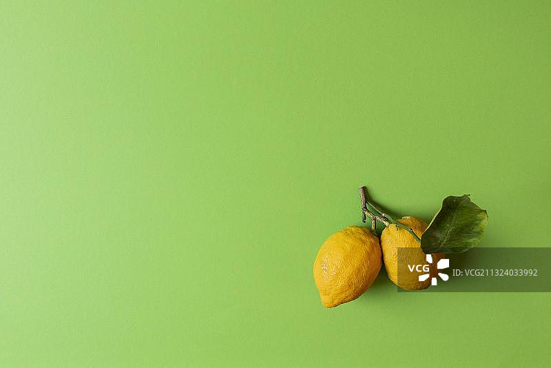 绿色背景下的两个新鲜有机柠檬图片素材