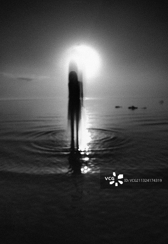 日出时站在海边的人的剪影图片素材