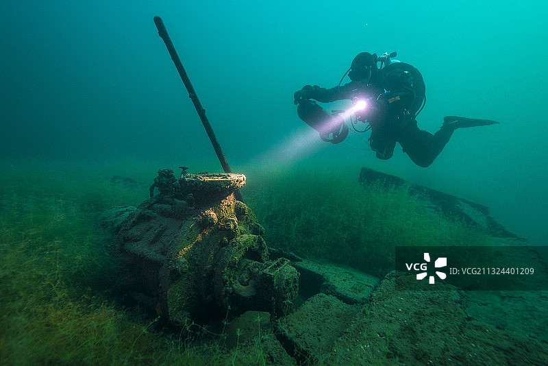 水肺潜水员在被淹矿井中探索露天采矿的残留物图片素材