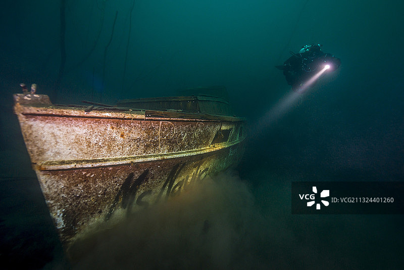 水肺潜水员探索采石场湖中的沉船图片素材