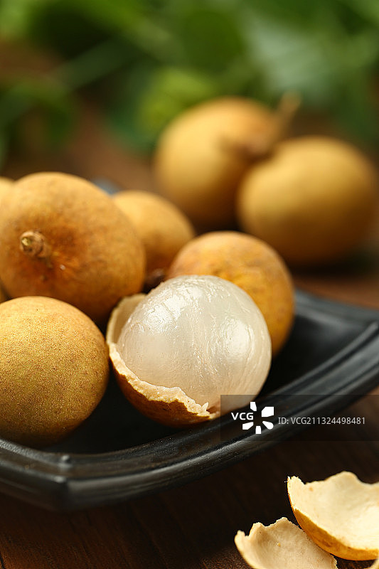 剥开的新鲜龙眼桂圆放在黑色盘子里图片素材