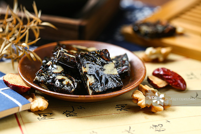 盘子里的阿胶糕，阿胶膏和食材放在药方背景上图片素材