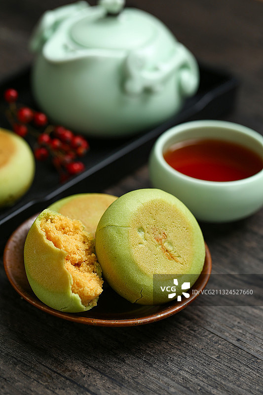 绿豆饼和红茶茶壶放在黑色背景上图片素材