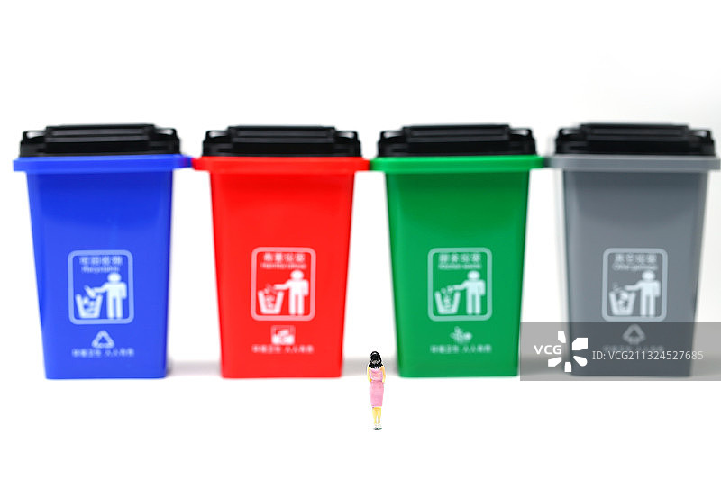 穿着粉红色裙子的女人模型站在垃圾分类垃圾桶前图片素材