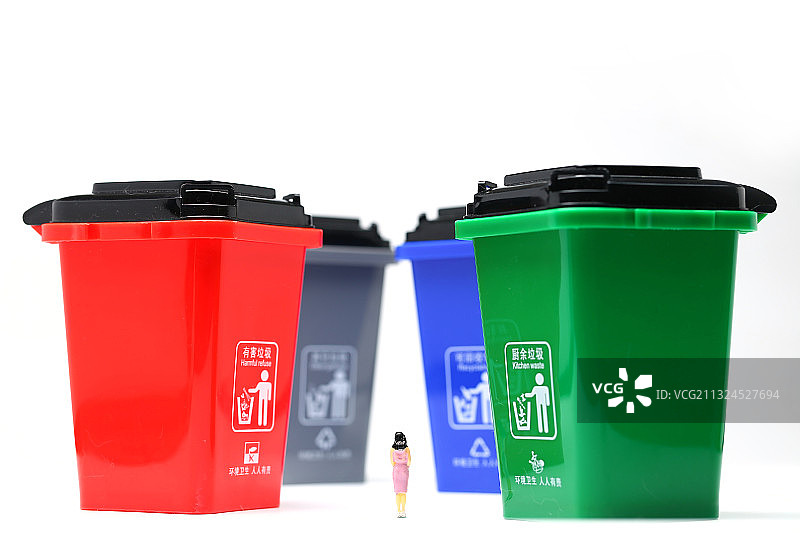 穿着粉红色裙子的女人模型站在垃圾分类垃圾桶前图片素材