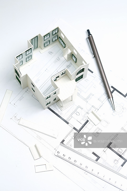 房屋模型和建筑图纸放在白色桌面上图片素材