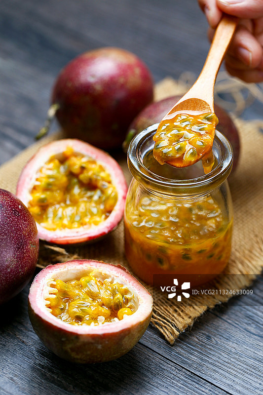 百香果和果汁放在粗麻布和深色桌面上图片素材