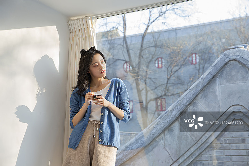 青年女子居家休闲喝咖啡看风景图片素材