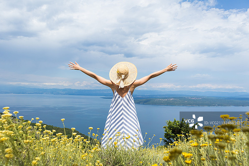 站在鲜花植物前的女子背影图片素材