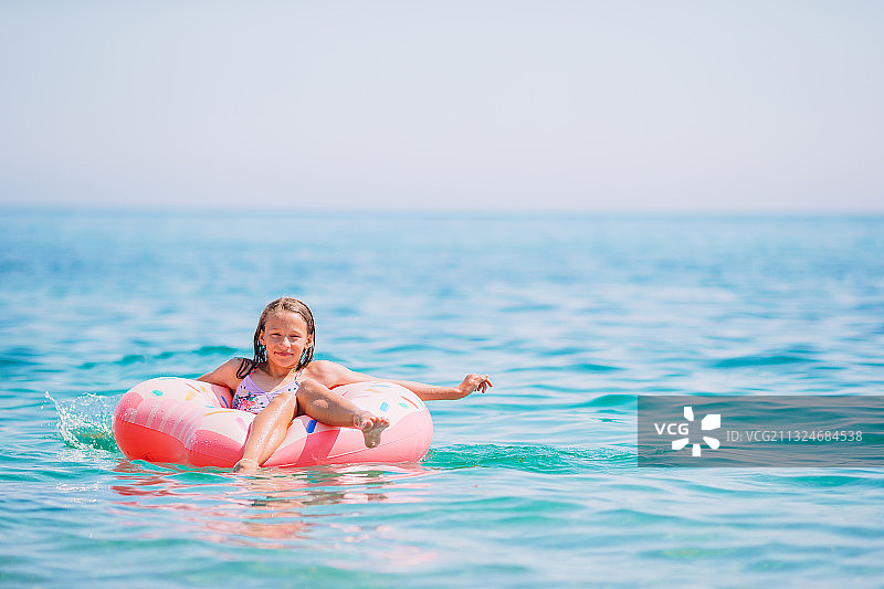在海上充气床垫上的可爱女孩图片素材
