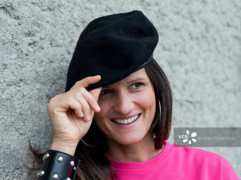 靠在意大利墙上戴帽子的微笑女子 портрет图片素材