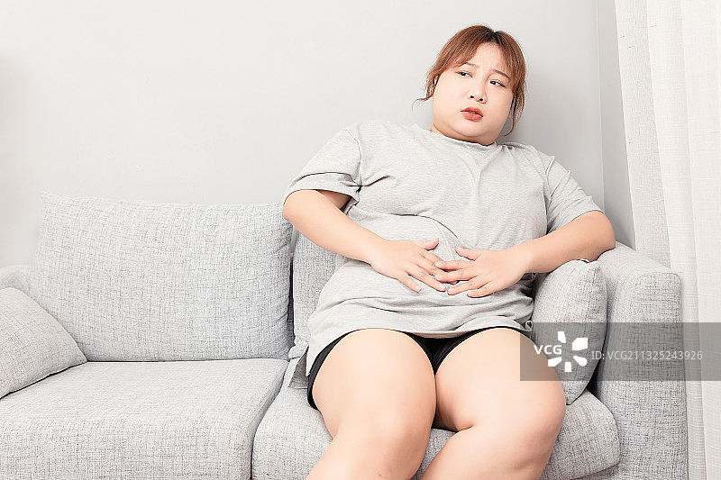 坐在沙发上的亚洲胖女孩图片素材