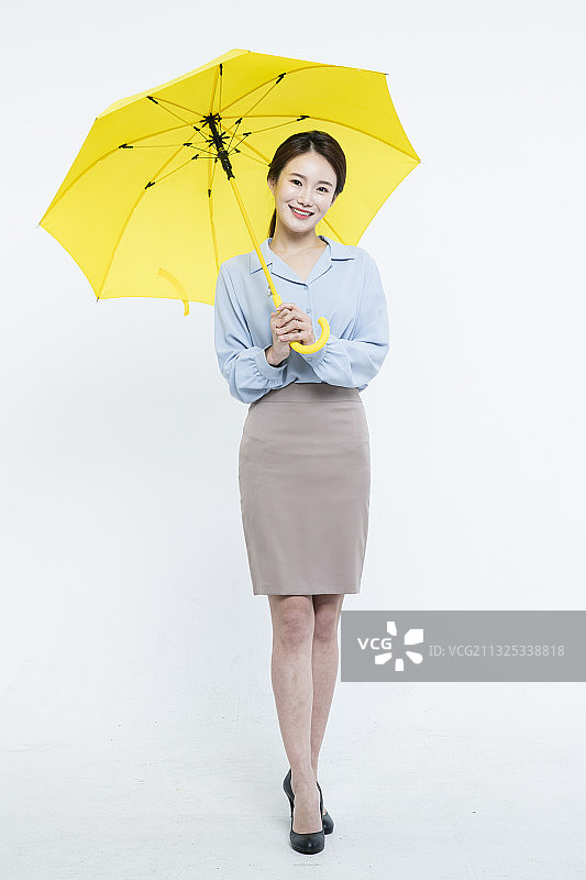 手持黄色雨伞的亚洲女商人图片素材