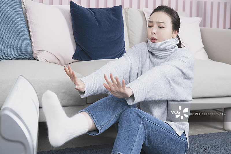 亚洲单身女性独自一人在冬天使用电暖器图片素材
