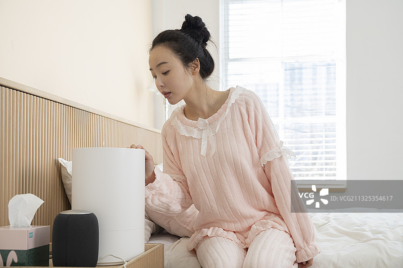 穿着睡衣的亚洲女人和床头灯图片素材
