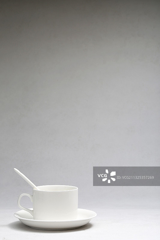 白色咖啡杯放在灰色渐变背景前图片素材