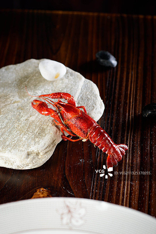 木板桌上的石块上的一只小龙虾图片素材