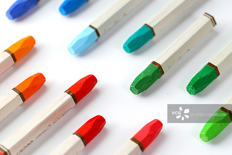 整齐排列的油画棒放在白色背景上图片素材