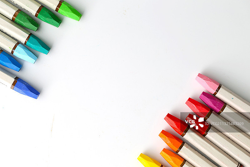 整齐排列的油画棒放在白色背景上图片素材